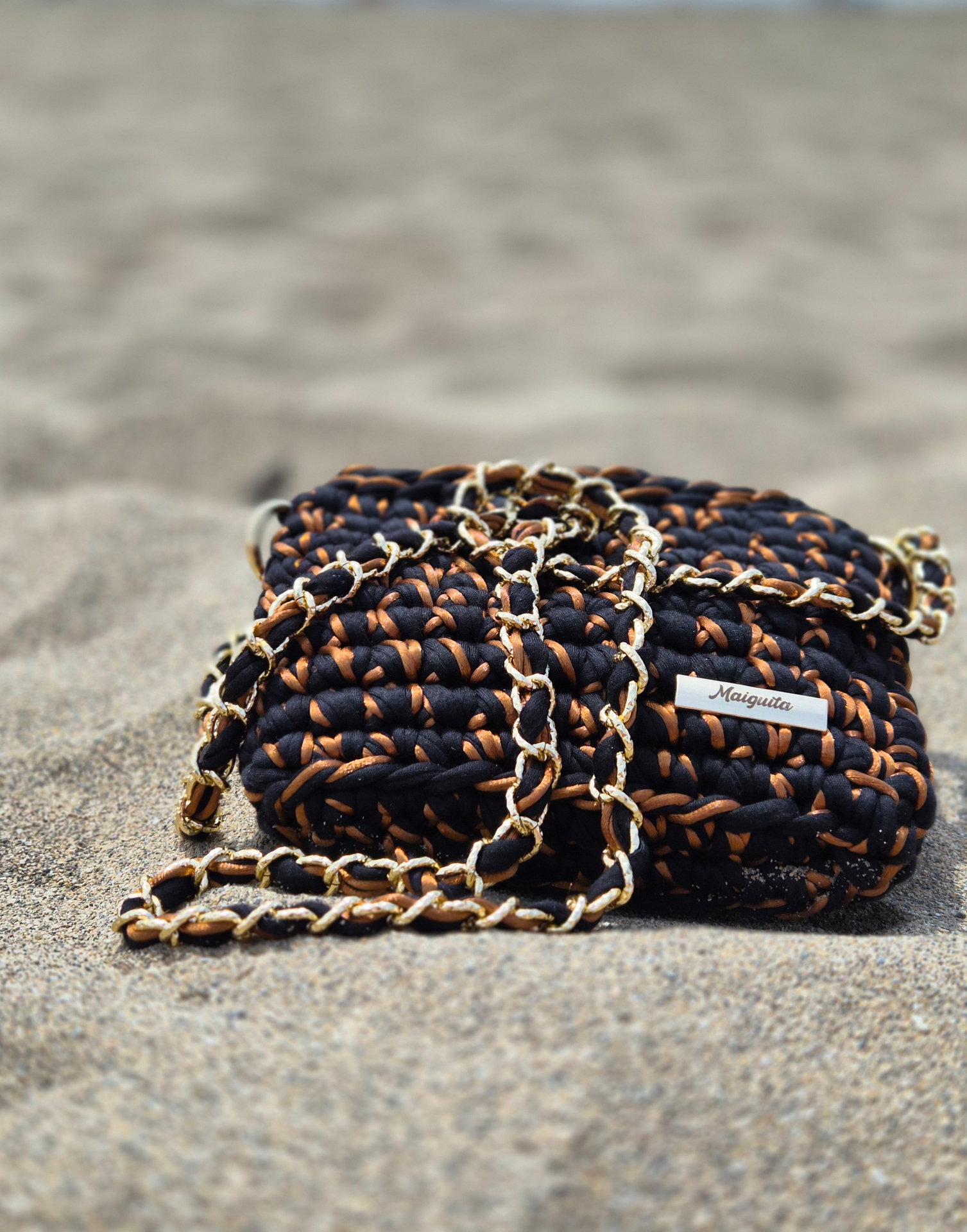 Bolso Maiguita tejido en negro y cobre con cadena dorada